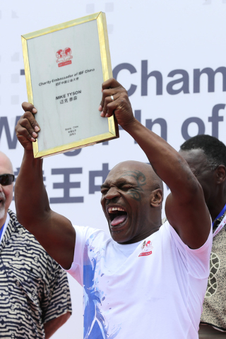 Former heavyweight boxing champion Mike Tyson reacts as he is awarded the charity ambassador of IBF China during the weigh-in ceremony of the 2016 IBF World Championship Bout at the Mutianyu secti ...