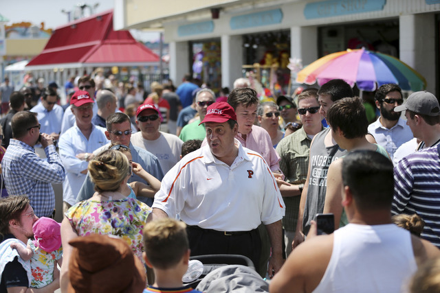 New Jersey Gov. Chris Christie, center, greets people as he walks along an already crowded boardwalk to kick off the Memorial Day holiday weekend at the Jersey Shore Friday, May 27, 2016, in Point ...