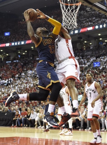 Cleveland Cavaliers forward LeBron James drives to the basket against Toronto Raptors forward James Johnson during the second half of Game 6 of the NBA basketball Eastern Conference finals, Friday ...