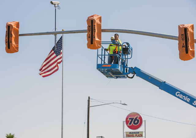 A work crew installs the first traffic light in Baker, Cal. on Monday, May, 23, 2016. The owner of Baker Travel Plaza spent four years trying to install the signal because it is cheaper than a tra ...