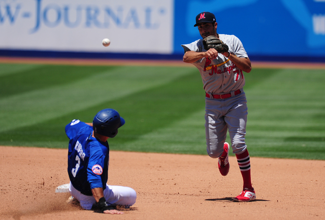 Memphis Redbirds shortstop Alex Mejia turns a double play as Las Vegas 51s base runner T.J. Rivera slides into second base in the fourth inning of their Triple-A minor league baseball game at Cash ...