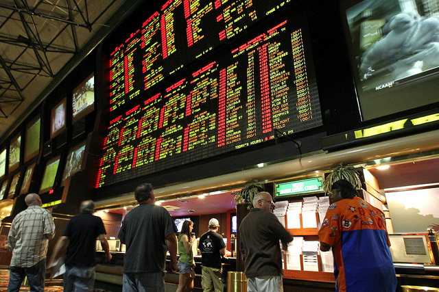 Bettors stand below the NCAA Basketball tournament betting boards at the Las Vegas Hilton Race & Sports Book Monday March 14, 2011. (John Gurzinski/Las Vegas Review-Journal)