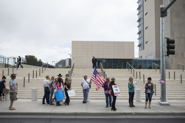 People, including Doug Knowles of Pahrump, center, protest outside of the Lloyd George Federal Building ahead of an arraignment for Ammon and Ryan Bundy, among others, in Las Vegas on Friday, Apri ...