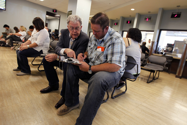 Dave Bundy,, right, son of rancher Cliven Bundy, and informal family advisor Joel Hansen fill out the paperwork to file official complaints and press charges against federal law enforcement agents ...