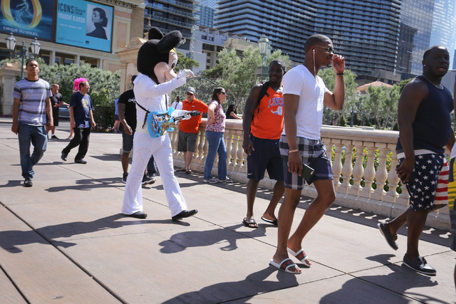 A Mickey Mouse impersonator walks down the sidewalk in front of the Bellagio hotel-casino on the Strip in Las Vegas on Friday, May 27, 2016. (Brett Le Blanc/Las Vegas Review-Journal) Follow @blebl ...