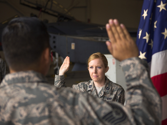 Capt. Madison Gilbert, officer in charge at the 757th Aircraft Maintenance Squadron, re-enlists Tech Sgt. Darren Garcia during a ceremony at Nellis Air Force Base on Wednesday, April 27, 2016.  (J ...