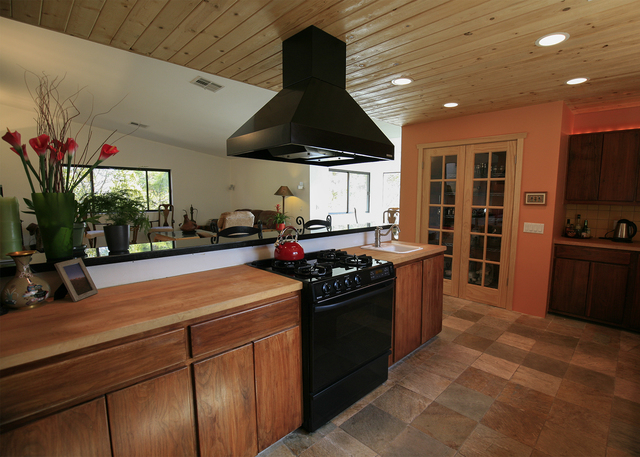 The kitchen has solid walnut cabinets. Its ceiling is made of knotty pine, and it has an eating nook looking east over the orchard. (ELKE COTE/MILLIONS)