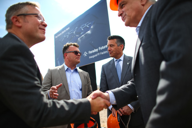 Faraday Future Vice President of Manufacturing Dag Reckhorn, center left, and Gov. Brian Sandoval speak with each other following the groundbreaking for Faraday Future's planned 900-acre manufactu ...