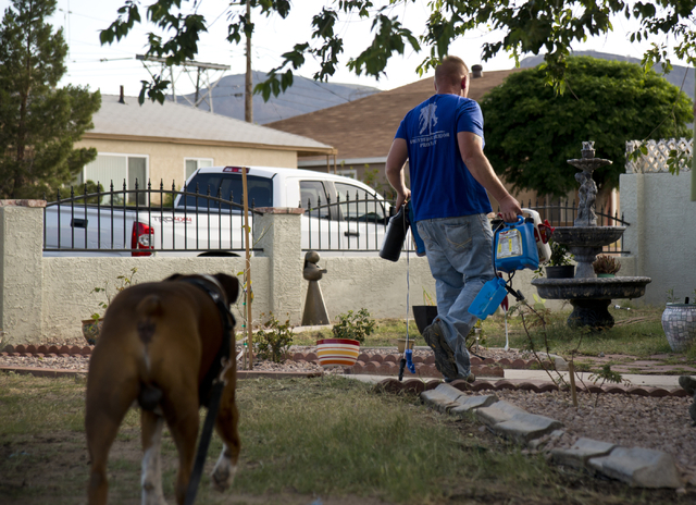 Retired Sgt. Maj. Robert Brown cleans up before Marina Vance arrives to see the new landscaping he and volunteers created as part of a Blue Star Mothers of Henderson and Boulder City project on Sa ...