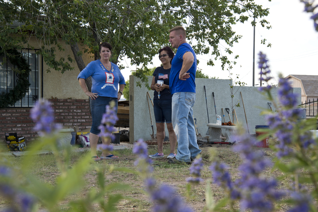Retired Sgt. Maj. Robert Brown, right, and Cher Pedersen, left, show Marina Vance, center, the new landscaping done by volunteers as part of a Blue Star Mothers of Henderson and Boulder City proje ...