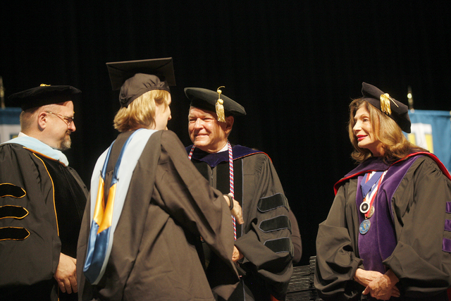 Dr. Ray Alden shakes a student's hand at Touro University Nevada's graduation ceremony alongside Rabbi Fromowitz, left, and former Congresswoman Shelley Berkley, right, at the Rio Hotel and Casino ...