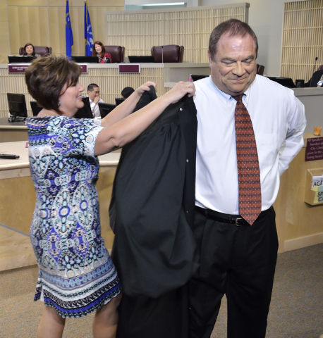 Rodney Burr gets some help from his wife Annette during a robing ceremony after he was sworn in as municipal judge at Henderson City Hall at 240 S. Water St. in Henderson on Tuesday, May 17, 2016. ...