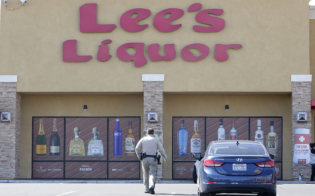 A metro police officer investigates Tuesday, April 19, 2016, after the Lee's Discount Liquor employee, Matthew Christensen, 24, was shot and killed during a robbery Monday night at the liquor stor ...