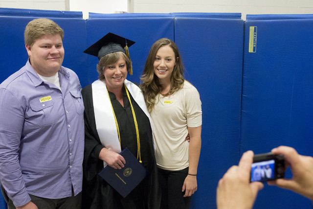 Inmate Alica Wegner, center, takes a photo with her children Justin and Jaclyn after receiving her bachelor's degree at the Florence McClure Women's Correctional Center's graduation ceremony in La ...