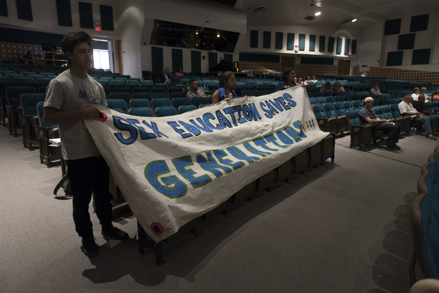 Clark High School graduates hold pro sex ed banners into the auditorium during a Clark County School District Board of Trustees meeting to discuss sex ed curriculum at Las Vegas Academy in Las Veg ...