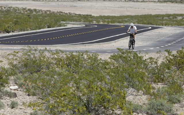 Dave Eckland of Henderson rides his bike on the first paved access road to Sloan Canyon National Conservation Area on Thursday, May 19, 2016. The BLM Thursday dedicated the road and other visitor  ...