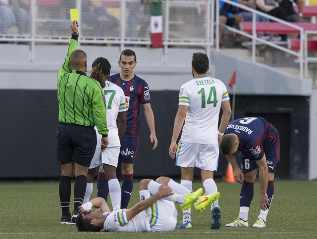 New York Cosmos' Sebastian Guenzatti (13) lays on the ground in pain as an SD Eibar defender is given a yellow card, Wednesday, May 25, 2016, at Sam Boyd Stadium in Las Vegas. Benjamin Hager/Las V ...