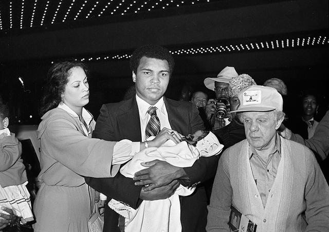 Muhammad Ali carries his daughter Laila Amaria Ali while arriving at the Las Vegas Hilton with wife Veronica Porsche Ali Feb. 5, 1978. (Las Vegas News Bureau)