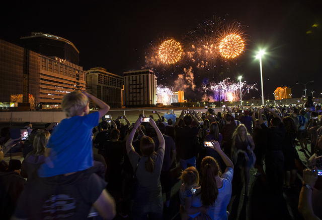 People watch fireworks before the implosion of the Monaco tower at the Riviera Hotel & Casino from the parking lot of the Peppermill in Las Vegas on Tuesday, June 14, 2016. CREDIT: Chase Steve ...