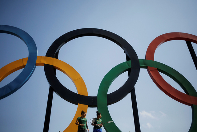 Brazilian badminton players Lohaynny Vicente, left, 20, and her sister Luana Vicente, 22, stand under a set of Olympic rings installed at Madureira Park in Rio de Janeiro, May 4, 2016. (Nacho Doce ...