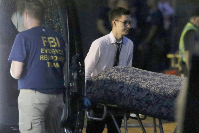 Police forensic investigators work at the crime scene of a mass shooting, as bodies are removed at the Pulse gay night club in Orlando, Florida, U.S. June 12, 2016.   (Jim Young/Reuters)