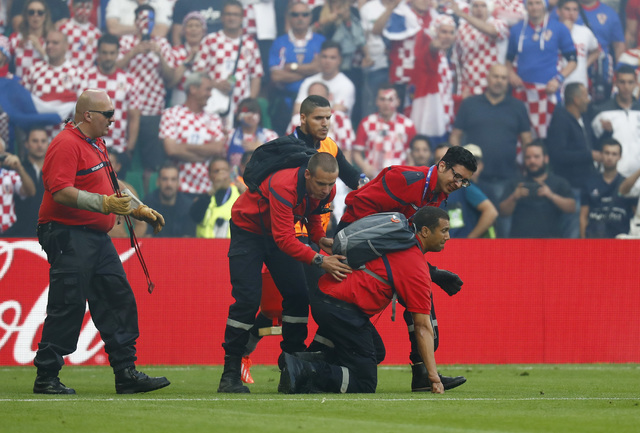 Stewards deal with flares that have been thrown onto the pitch during the Euro 2016 Group D soccer match between the Czech Republic and Croatia at the Geoffroy Guichard stadium in Saint-Etienne, F ...