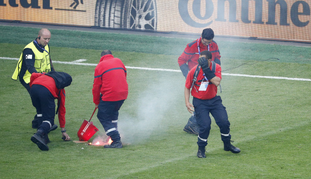 Stewards tend to flares that have been thrown onto the pitch by fans during the Euro 2016 Group D soccer match between the Czech Republic and Croatia at the Geoffroy Guichard stadium in Saint-Etie ...