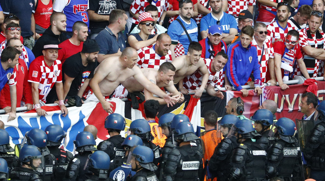 Croatia fans are watched by police during the Euro 2016 Group D soccer match between the Czech Republic and Croatia at the Geoffroy Guichard stadium in Saint-Etienne, France, Friday, June 17, 2016 ...