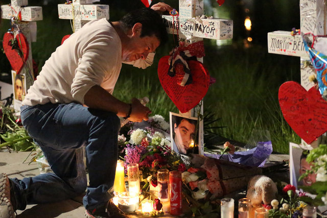 Jose Louis Morales cries on his knees at his brother Edward Sotomayor Jr.'s cross, that is part of a makeshift memorial for the victims of the Pulse night club shootings in Orlando, Florida, U.S., ...