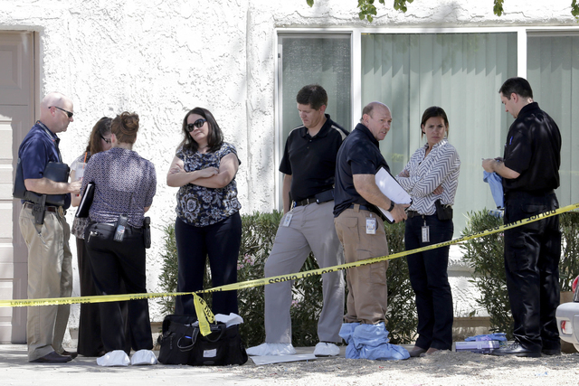 Law enforcement officials stand outside a home, Thursday, June 2, 2016 in Phoenix where three boys were killed during a several hour period Wednesday night. The boy's mother was hospitalized in c ...