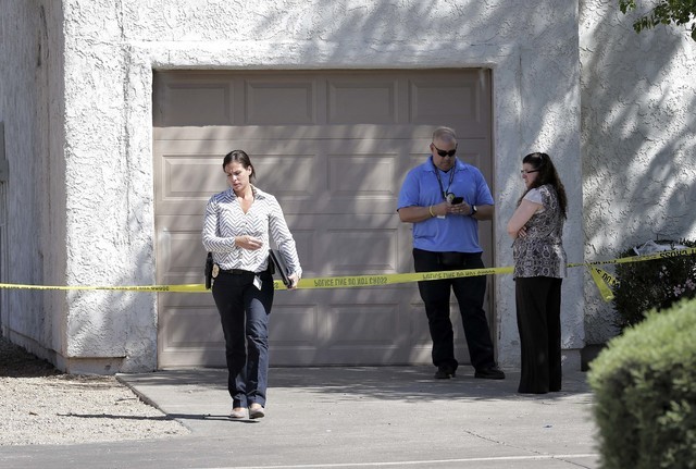 Phoenix police detectives stand outside a home, Thursday, June 2, 2016 in Phoenix where three boys were killed during a several hour period Wednesday night.  The boy's mother was hospitalized in c ...