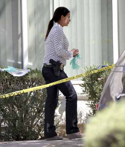 A Phoenix police detective prepares to enter a home, Thursday, June 2, 2016 in Phoenix where three boys were killed during a several hour period Wednesday night.  The boy's mother was hospitalized ...
