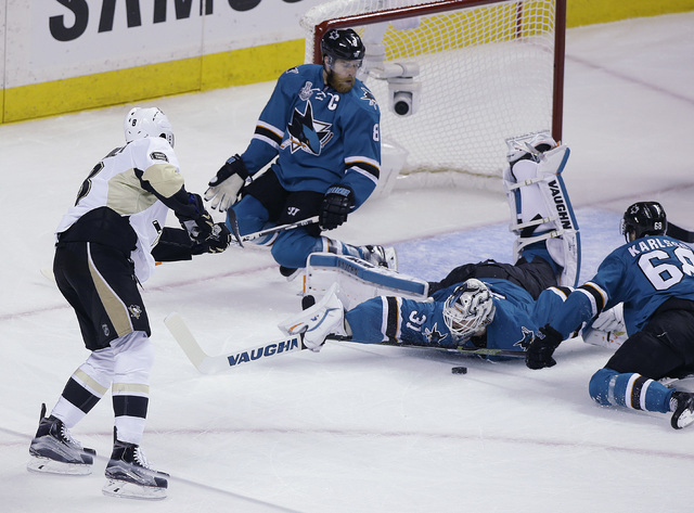 San Jose Sharks goalie Martin Jones (31) blocks a shot by Pittsburgh Penguins' Brian Dumoulin, left, during the second period of Game 4 of the NHL hockey Stanley Cup Finals, Monday, June 6, 2016,  ...