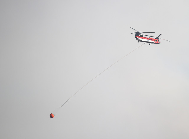A helicopter aids in the effort to extinguish a brush fire in Yarnell, Ariz., Wednesday, June 8, 2016. T (Les Stukenberg/The Daily Courier via AP)