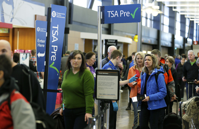 Travelers authorized to use the Transportation Security Administration's PreCheck expedited security line at Seattle-Tacoma International Airport in Seattle have their documents checked by TSA wor ...