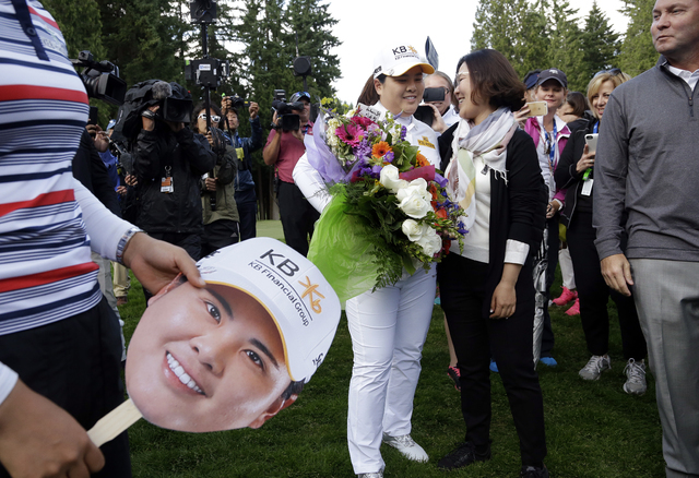 Inbee Park, center left, of South Korea, is embraced after finishing the first round at the Women's PGA Championship golf tournament at Sahalee Country Club on Thursday, June 9, 2016, in Sammamish ...