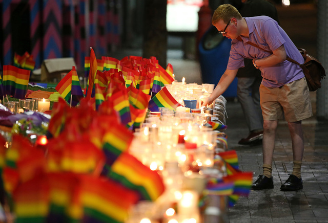 A man looks over an impromptu candlelit memorial set up in Sydney, Monday, June 13, 2016, following the Orlando, Florida, mass shooting where police say a gunman killed at least 50 people and woun ...