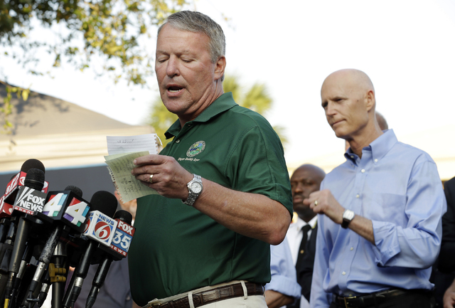 Orlando, Fla., Mayor Buddy Dyer reads details of the fatal shootings at Pulse Orlando nightclub during a media briefing Monday, June 13, 2016, in Orlando. Looking on is Florida Gov. Rick Scott at ...