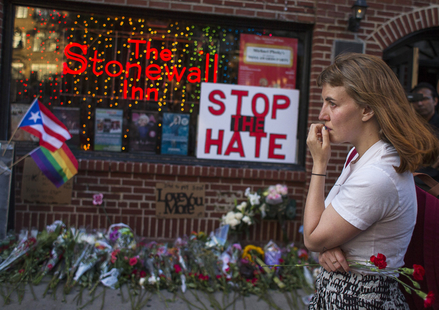 A woman cries and holds flowers in front of a makeshift memorial to remember the victims of a mass shooting in Orlando, Fla., in New York, Sunday, June 12, 2016. (Andres Kudacki/AP)