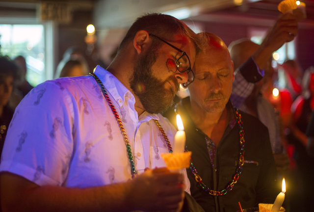 Don Haller, left, and Frank Thompson of Laguna Niguel pray for the victims of Orlando nightclub shooting at Main Street Bar in Laguna Beach, Calif., on Sunday, June 12, 2016. (Kyusung Gong/The Ora ...