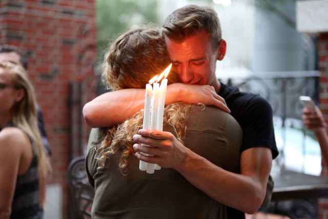 Brett Morian, from Daytona Beach, hugs an attendee during the candlelight vigil at Ember in Orlando, Fla., on Sunday, June 12, 2016.  (Joshua Lim/Orlando Sentinel via AP)