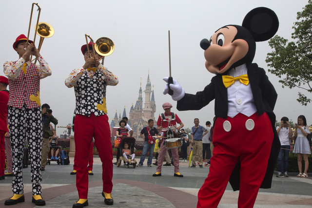 Mickey Mouse entertains visitors on the opening day of the Disney Resort in Shanghai, China, Thursday, June 16, 2016. Walt Disney Co. opened its first theme park in mainland China on Thursday. (Ng ...