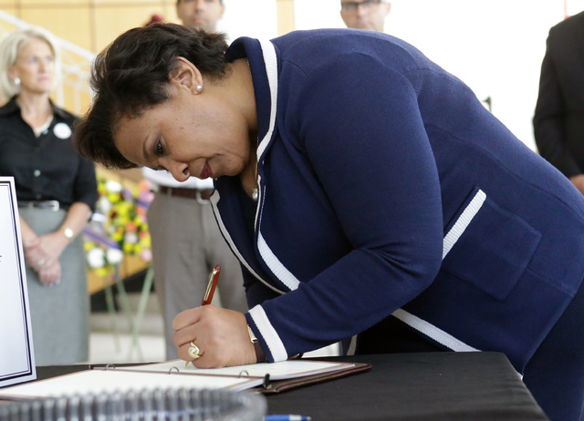 Attorney General Loretta Lynch writes in a book at City Hall expressing sympathy and condolences to the victims of the Pulse nightclub mass shooting, Tuesday, June 21, 2016, in Orlando, Fla. (John ...