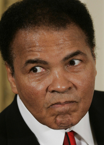 Former boxer Muhammad Ali playfully scowls at photographers before being presented with the Presidential Medal of Freedom, the U.S. government's highest civilian award, Wednesday, Nov. 9, 2005, ...