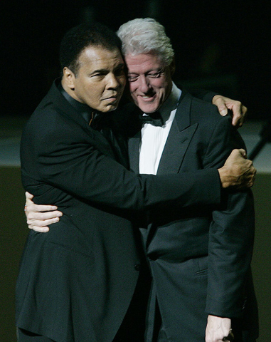 Former boxer Muhammad Ali, left, hugs former U.S. President Bill Clinton as he walks onstage at the grand opening gala celebration for the Muhammad Ali Center, Saturday, Nov. 19, 2005, in Louisvil ...