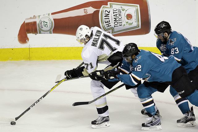 Pittsburgh Penguins' Evgeni Malkin, left, moves the puck past San Jose Sharks' Joel Ward (42) and Matt Nieto (83) during the first period of Game 4 of the NHL hockey Stanley Cup Finals on Monday, ...