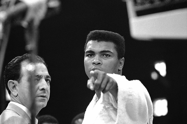 Heavyweight champion Muhammad Ali is momentarily displeased after weigh-in ceremony, May 25, 1965 in Lewiston, Maine, arena. Challenger Sonny Liston will be the object of Ali's more potent attenti ...
