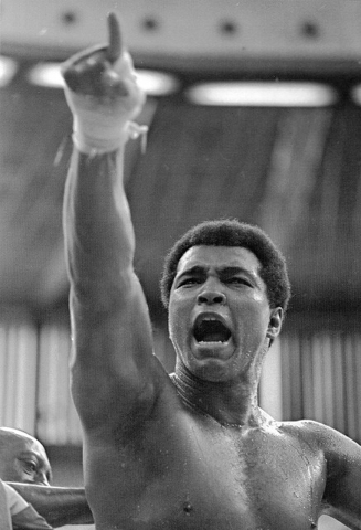 FILE - In this June 15, 1975, file photo, world heavyweight champion Muhammad Ali shouts "Joe Bugner must go!" to Malaysian fans during a training session for his fight against Bugner in Kuala Lum ...