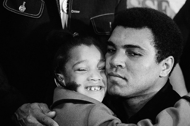 World Heavyweight Champ Muhammad Ali hugs Nicol Satina's ear before giving the six-year-old a kiss at a press conference with Ken Norton in New York on Wednesday, Sept. 29, 1976. (Marty Lederhandl ...