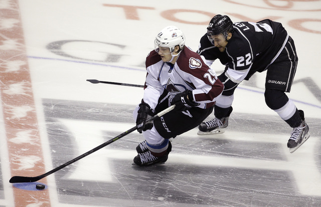Colorado Avalanche center Nathan MacKinnon (29) skates by Los Angeles Kings center Trevor Lewis (22) during their NHL preseason hockey game, Oct. 4, 2014, in Las Vegas. Colorado won 3-2 in a shoot ...
